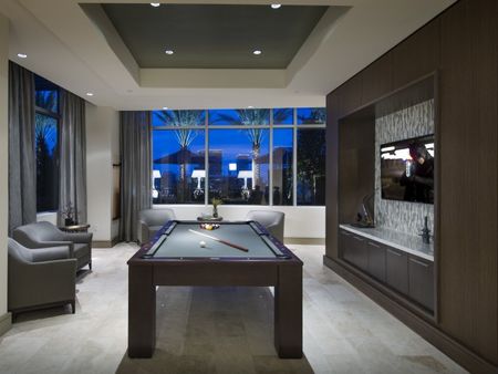 Room with billiards table, large windows, an HDTV, 4 armchairs, and stone floors