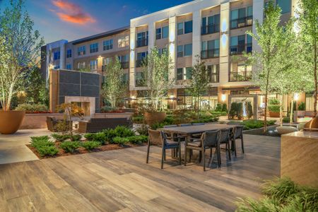 Expansive social courtyard featuring fireplaces surrounded by intimate seating areas, and grills with open-air dining areas