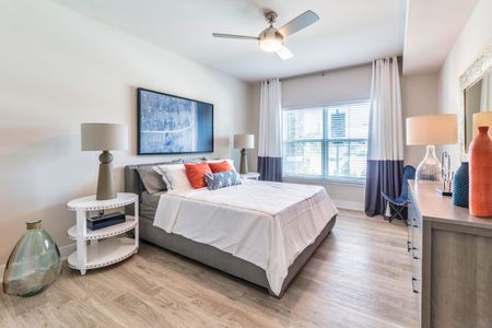 The Reserve at Coral Springs, interior, spacious bedroom, wood floors, bed, dresser, ceiling fan, large window