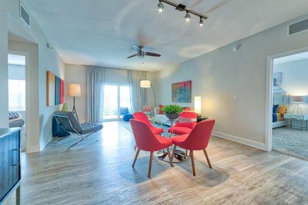 The Reserve at Vero Beach, interior, open concept, dining room, living room, ceiling fan, large sliding glass doors, wood floors, doorway to carpeted bedroom