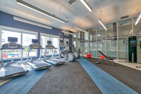 The Reserve at Vero Beach, interior, fitness center, treadmills, large windows, view of pool, hand weights, elliptical