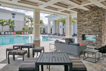 The Reserve at Coral Springs, exterior, sparkling blue swimming pool, clubhouse, lounge chairs, outdoor seating, fireplace