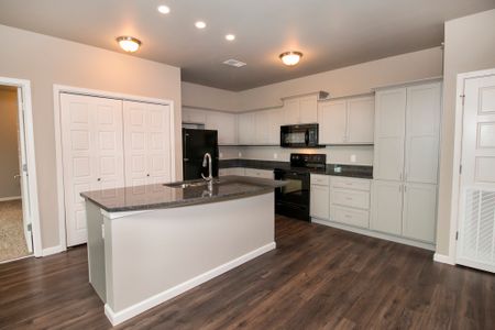 Coryell Commons 55+ kitchen with hardwood floors and granite counters