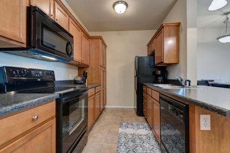 Coryell Courts furnished kitchen with black appliances