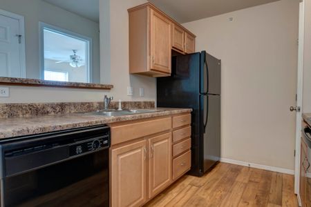 Coryell Crossing Apartments kitchen with black appliances and hardwood style flooring