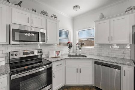 Kitchen with stainless steel appliances and white tile