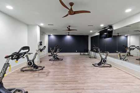 furnished fitness center with wall mirror