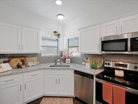 Kitchen with backsplash and white cabinets