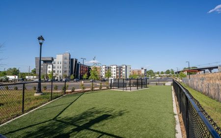 Fenced in dog park in front of apartment building
