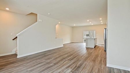 unfurnished living and kitchen area with stairs in townhome