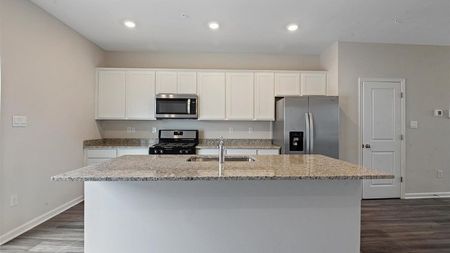 unfurnished kitchen area with island of townhome