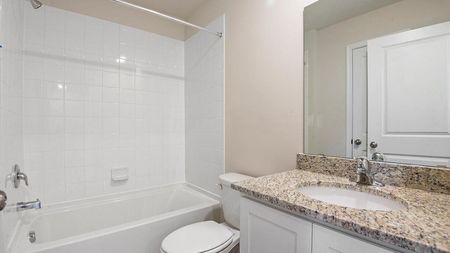 unfurnished bathroom with tub shower, toilet and sink in townhome