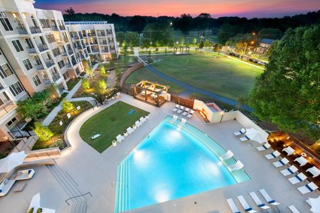 aerial shot of furnished pool area with apartment building at nighttime