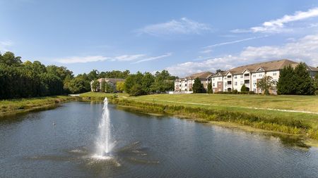 lake with fountain and apartment building