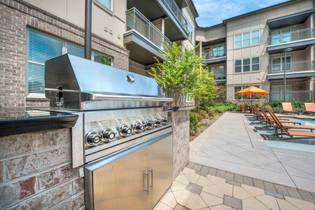 grilling station next to pool and apartment building on sunny day