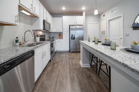 decorated kitchen with white cabinets and stainless steel appliances