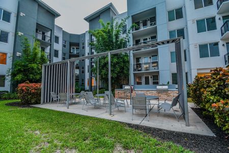 1 BR Apartments in Delray Beach, FL - Congress Grove - Grill Area with Tables, Chairs, BBQs, and Landscaping.