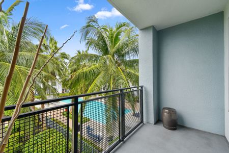 furnished balcony area of apartment home overlooking pool on sunny day