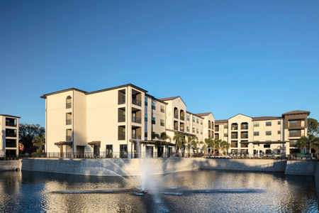exterior apartment building with lake and fountain on sunny day