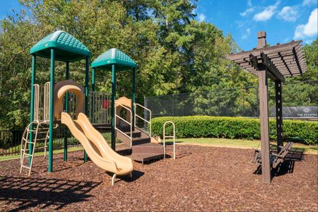 3-BR Apartments in Duluth, GA - Parc 85 - Outdoor Playground with Slide, Surrounded by Landscaping with an Adult Bench Swing.