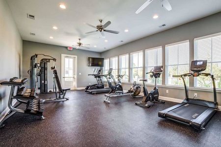 Apartment community gym with cardio machines and free weights