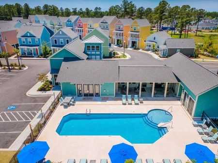 Birds eye view of colorful two story cottages and pool