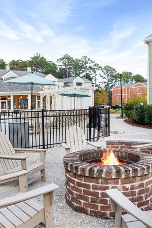 Apartments Near Johns Island Airport - Apartments at Shade Tree - Fire Pit near the Gated Pool with Patio Chairs.