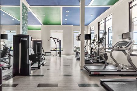 Indoor fitness center with tiled flooring, treadmill, ellipticals, and weight machines