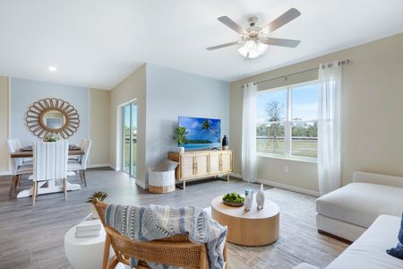 Furnished living room with lighted ceiling fan and large window with a clear view of the dining area with dining table