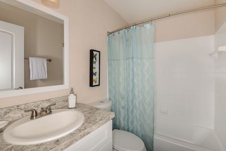 furnished bathroom with shower, countertop and toilet in apartment