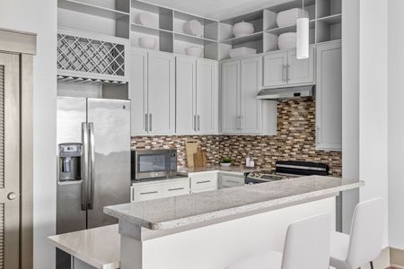 Kitchen with brown tile backsplash and stainless steel appliances