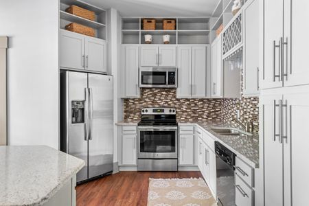 Kitchen with brown tile backsplash and stainless steel appliances