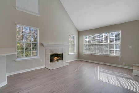 Luxury Apartments Orlando For Rent - Knightsbridge at Stoneybrook - Living Room with Vinyl Plank Flooring, Vaulted Ceiling, Fireplace, And Plenty Of Windows With Blinds.