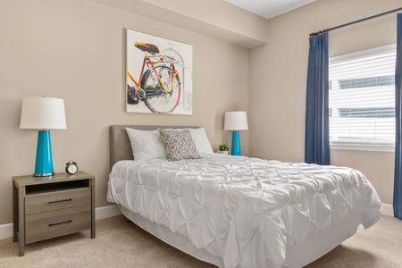 Furnished bedroom with bed, window, bedside tables and art