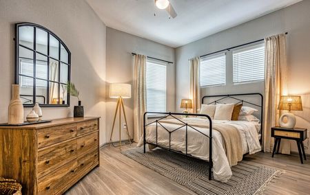 Pet-friendly Apartments in Pinellas Park, FL - Rowan Pointe - Furnished Bedroom With Wood-Style Flooring And Multiple Windows
