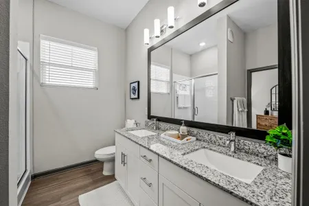furnished bathroom with countertop, sink, toilet and bathtub shower