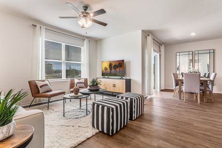 Furnished living room with chairs, ceiling fan and television