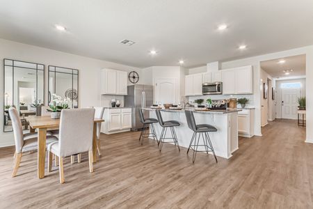 Furnished kitchen with stainless steel and black appliances and furnished dining room with table and chairs