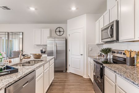 Kitchen with stainless steel and black appliances and white cabinets
