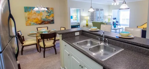 furnished kitchen and dining area with living room in apartment