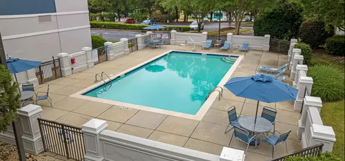 exterior pool with sundeck next to apartment building in daytime
