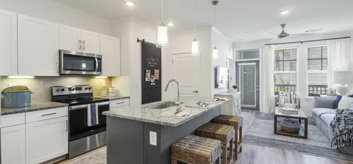 furnished kitchen and living area with island and sofa in apartment home