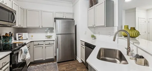 Furnished kitchen with stainless steel appliances and white cabinets