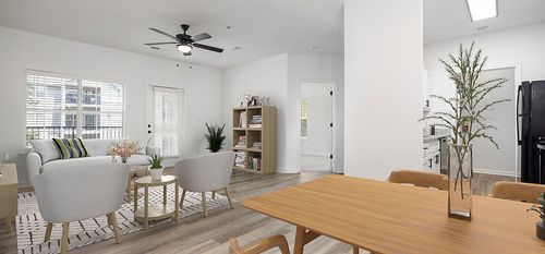 Modern open-concept living room featuring wooden furniture, a cozy seating area, and large windows letting in natural light.