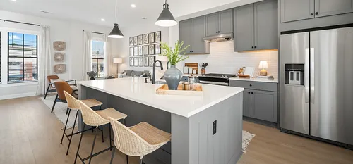 upscale kitchen with modern blue cabinetry, gas stove, large island, leading into outdoor balcony