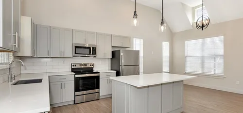 kitchen with light cabinetry and tall ceilings