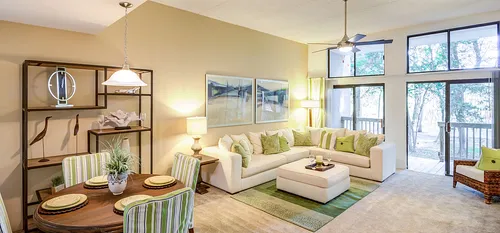 decorated living room with high ceilings and windows