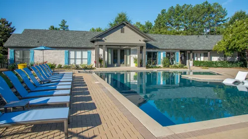 pool and furniture with apartment building on sunny day