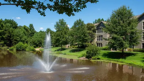 lake with water feature and apartment building on sunny day