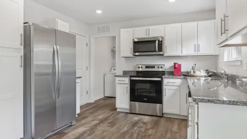 Kitchen with stainless steel and black appliances and white cabinets